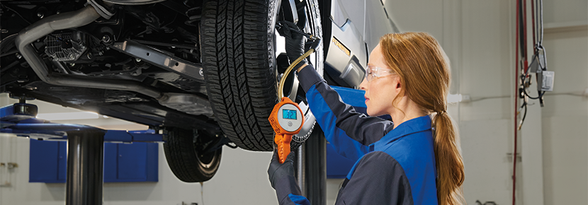 A Subaru technician checking tire pressure. | Sunset Hills Subaru in Sunset Hills MO