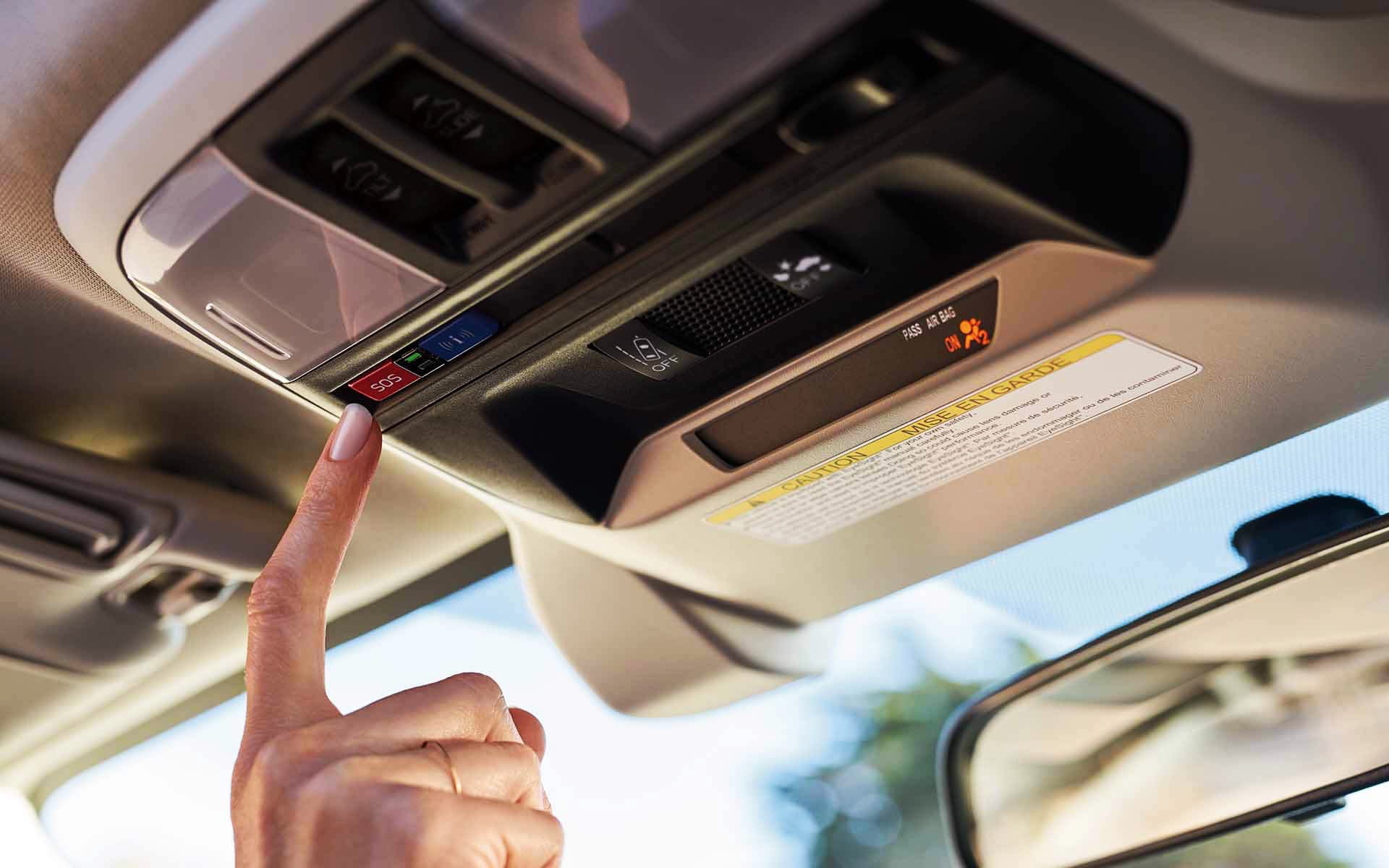 A finger pressing the Crosstrek Hybrid's SOS emergency assistance button | Sunset Hills Subaru in Sunset Hills MO