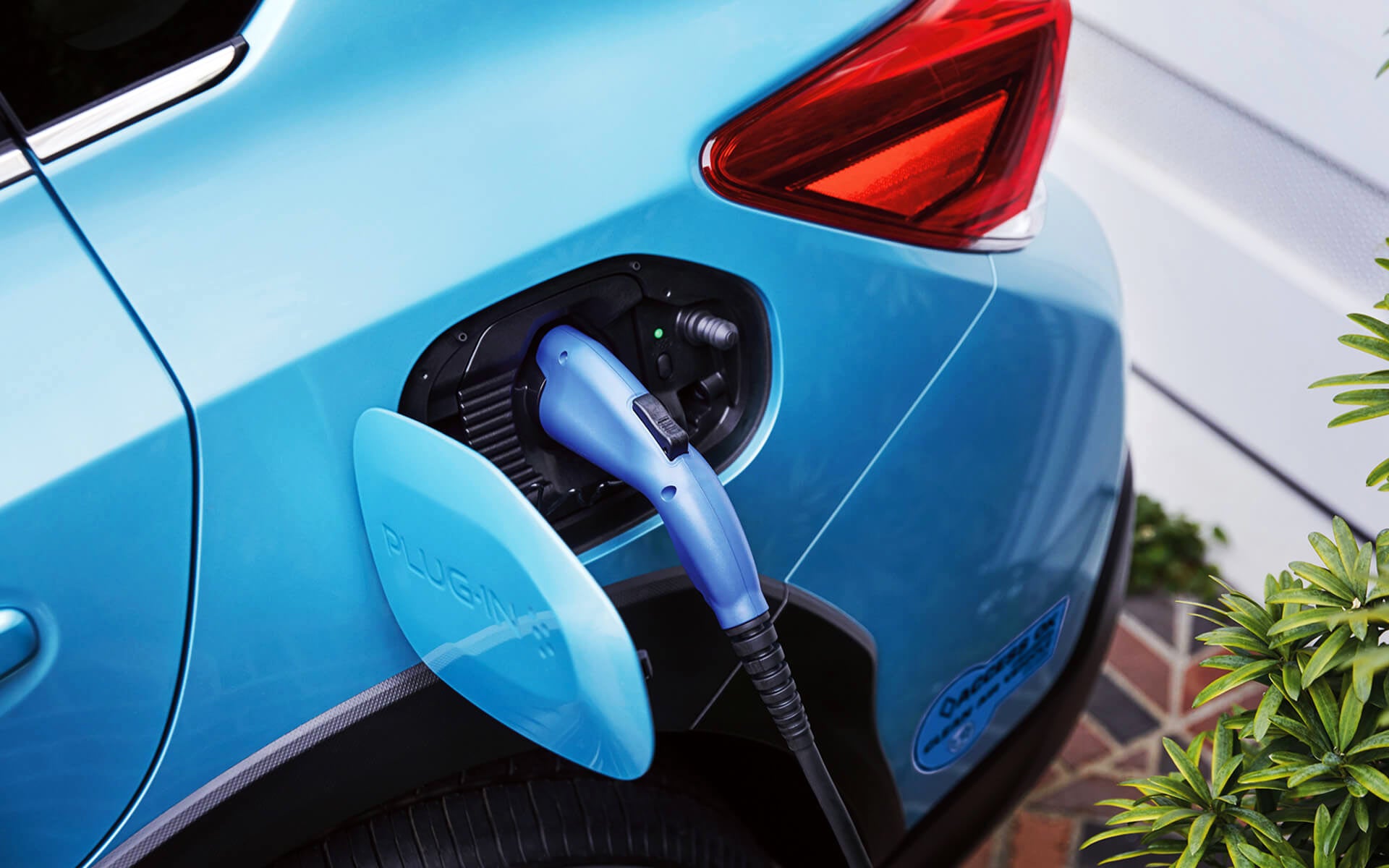 A close-up of the Subaru Crosstrek Hybrid's charging port with charging cable plugged in | Sunset Hills Subaru in Sunset Hills MO