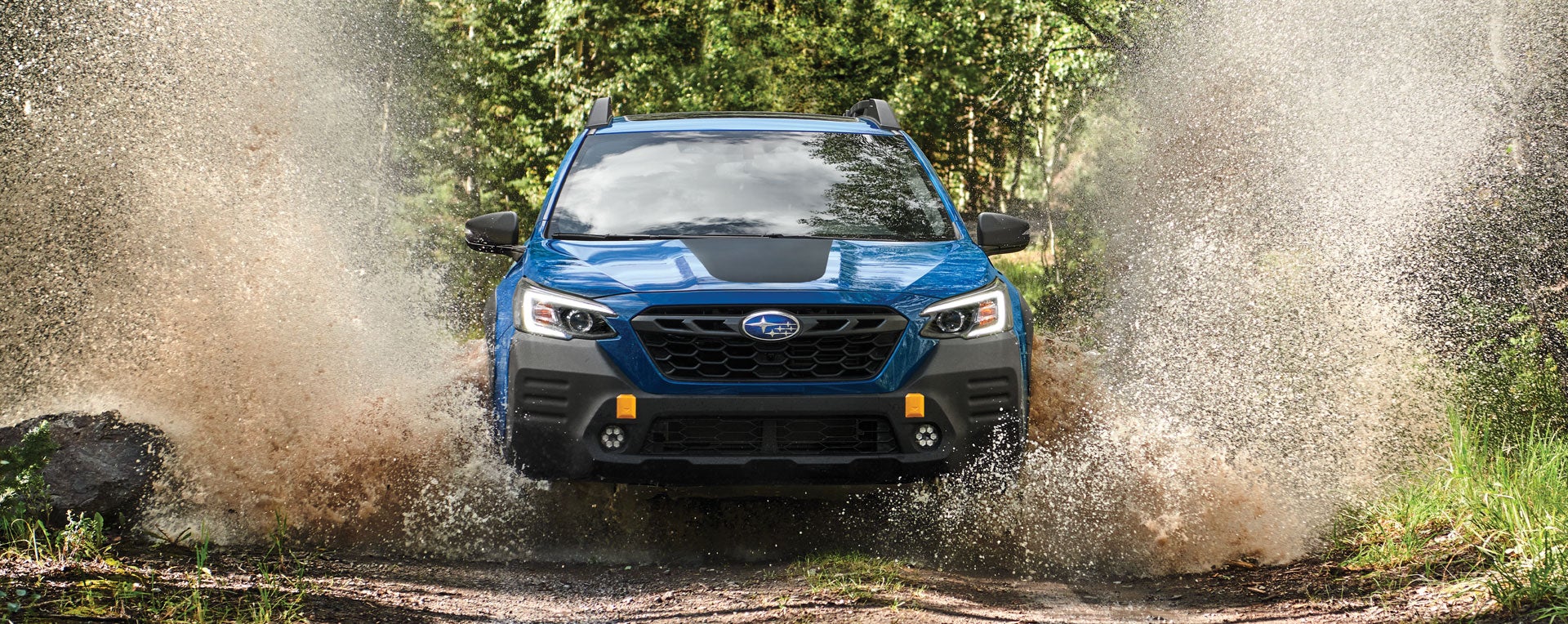 A 2023 Outback Wilderness driving on a muddy trail. | Sunset Hills Subaru in Sunset Hills MO