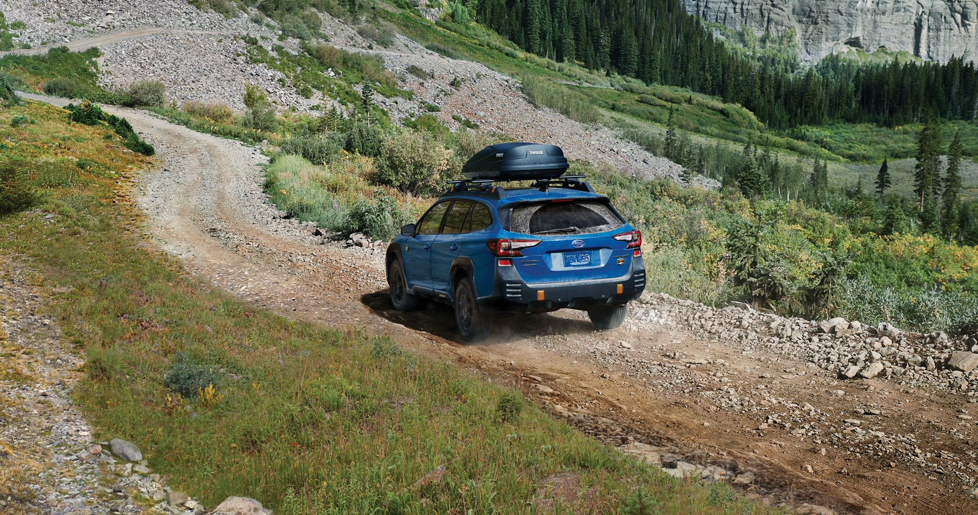 A 2023 Outback Wilderness driving on a trail in the mountains. | Sunset Hills Subaru in Sunset Hills MO