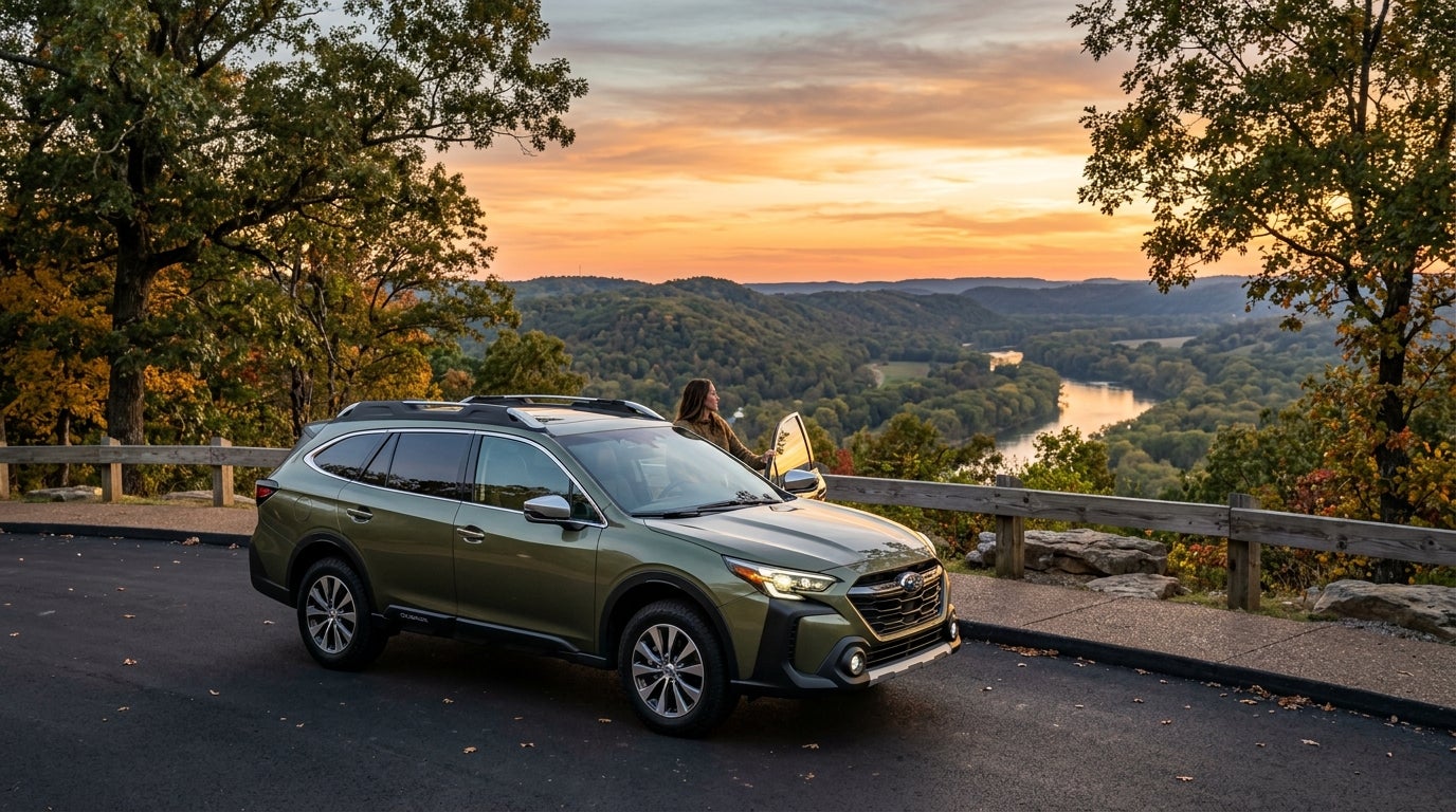 Olive green Subaru Outback parked at a scenic sunset overlook above a river valley with a woman standing nearby. (Representative image for illustration purposes only. Actual vehicle may vary based on trim and configuration.)